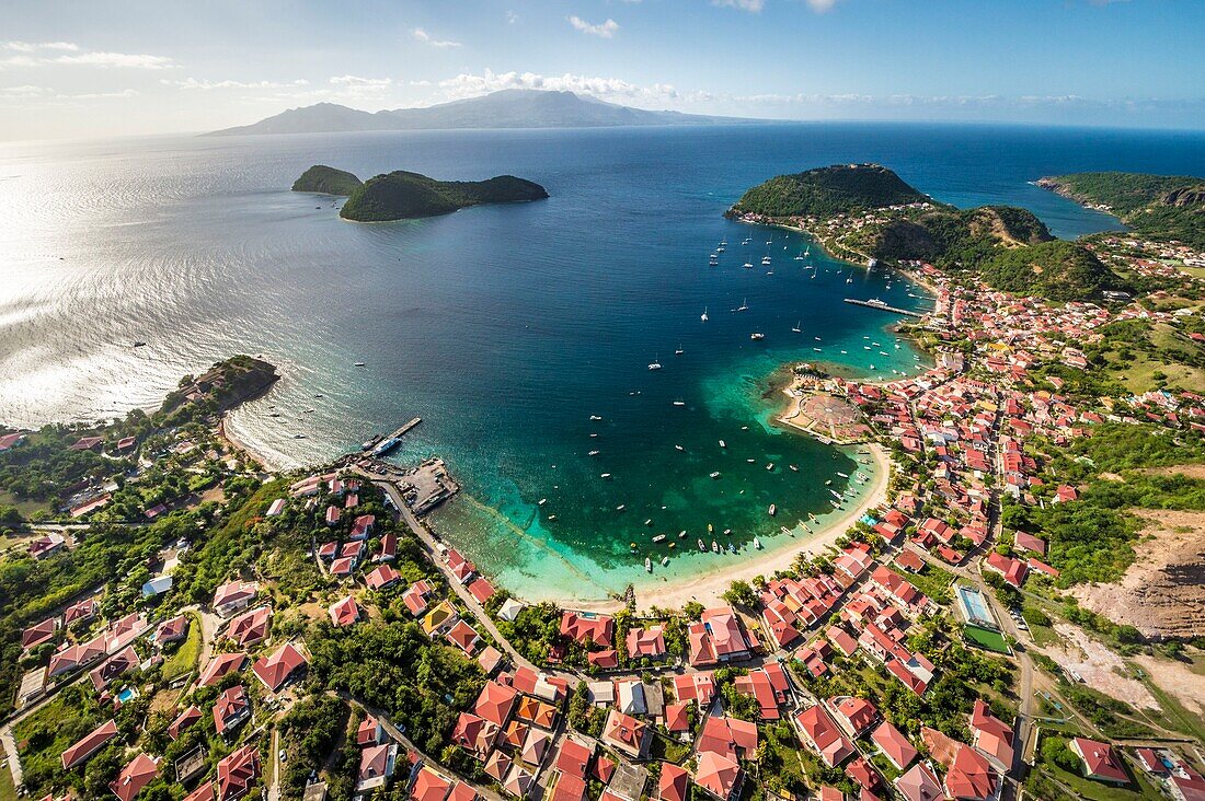 Guadeloupe, Les Saintes, Terre de Haut, die Bucht der Stadt Terre de Haut, die von der UNESCO zu den 10 schönsten Buchten der Welt gezählt wird, Basse Terre im Hintergrund (Luftaufnahme)