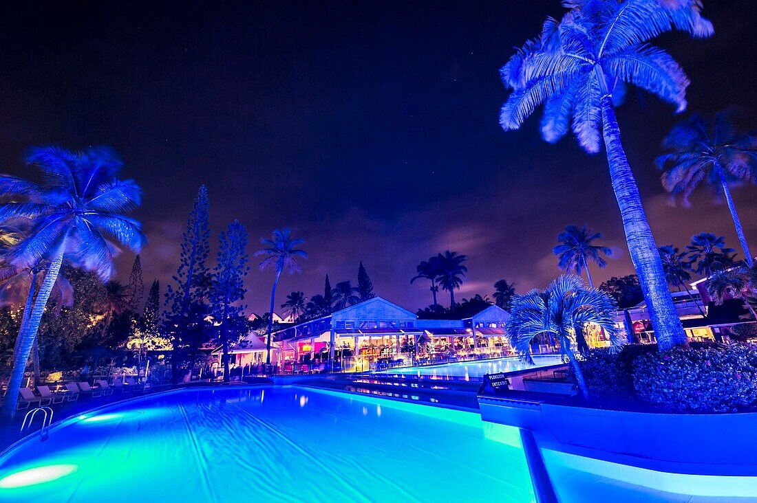 France, Caribbean, Lesser Antilles, Guadeloupe, Grande-Terre, Le Gosier, Creole Beach's garden and swimming pool by moonlight\n