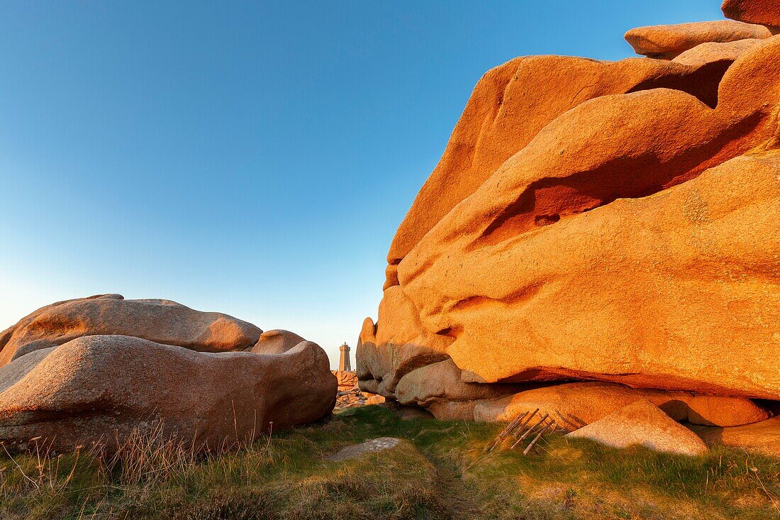 France, Cotes d'Armor, Pink Granite Coast, Perros Guirec, on the Customs footpath or GR 34 hiking trail, Ploumanac'h or Mean Ruz lighthouse at sunset\n