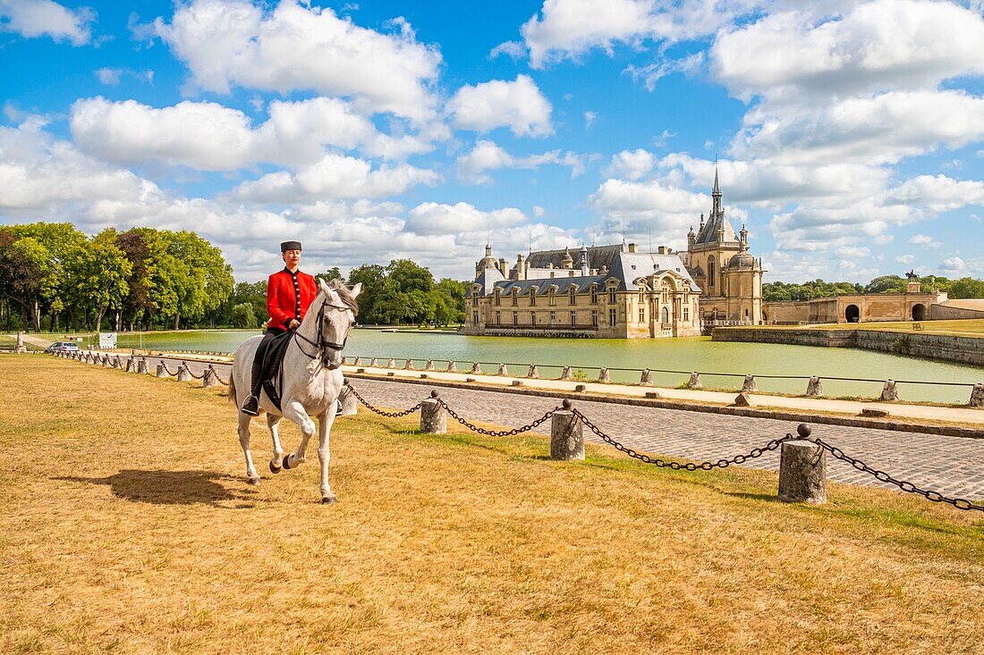 France, Oise, Chantilly, Chateau de Chantilly, the Grandes Ecuries (Great Stables), Estelle, rider of the Grandes Ecuries, runs his horse in Spanish steps in front of the castle\n