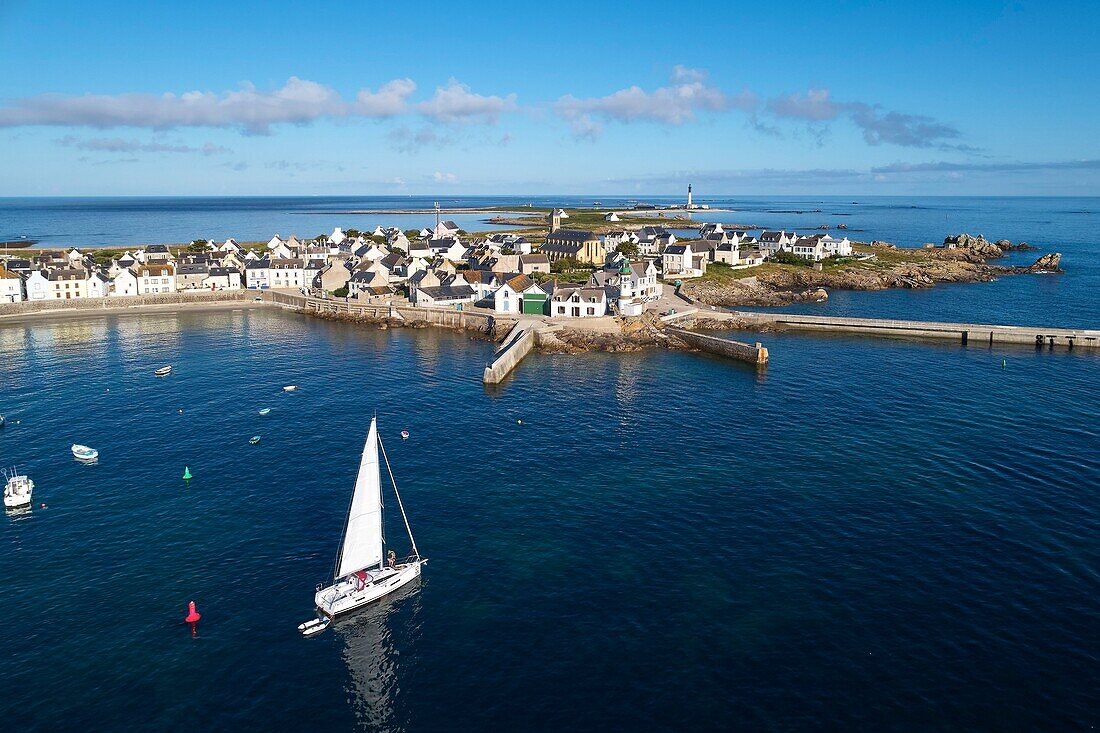 France, Finistere, Iroise Sea, Iles du Ponant, Parc Naturel Regional d'Armorique (Armorica Regional Natural Park), Ile de Sein, labelled Les Plus Beaux de France (The Most Beautiful Village of France), a sailboat in the harbour in front of the village (aerial view)\n