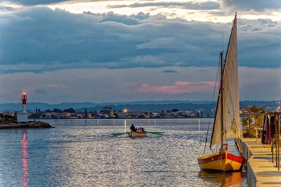 France, Herault, Sete, Pointe Courte, Latin sail in the foreground to the right with a traditional rowboat on the canal that leads to the Thau Lagoon\n