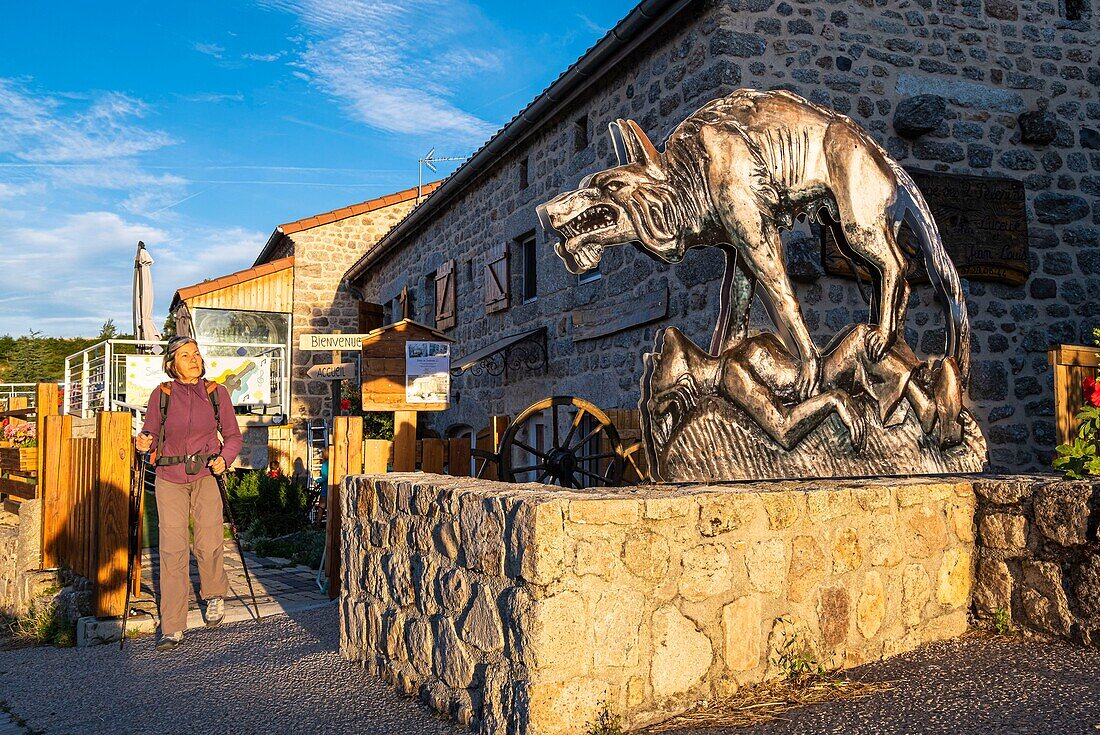 France, Haute-Loire, Chanaleilles, Le Villeret d'Apchier hamlet, hike along the Via Podiensis, one of the French pilgrim routes to Santiago de Compostela or GR 65, Beast of Gevaudan sculpture in front of the lodge L'Auberge des Deux Pélerins\n