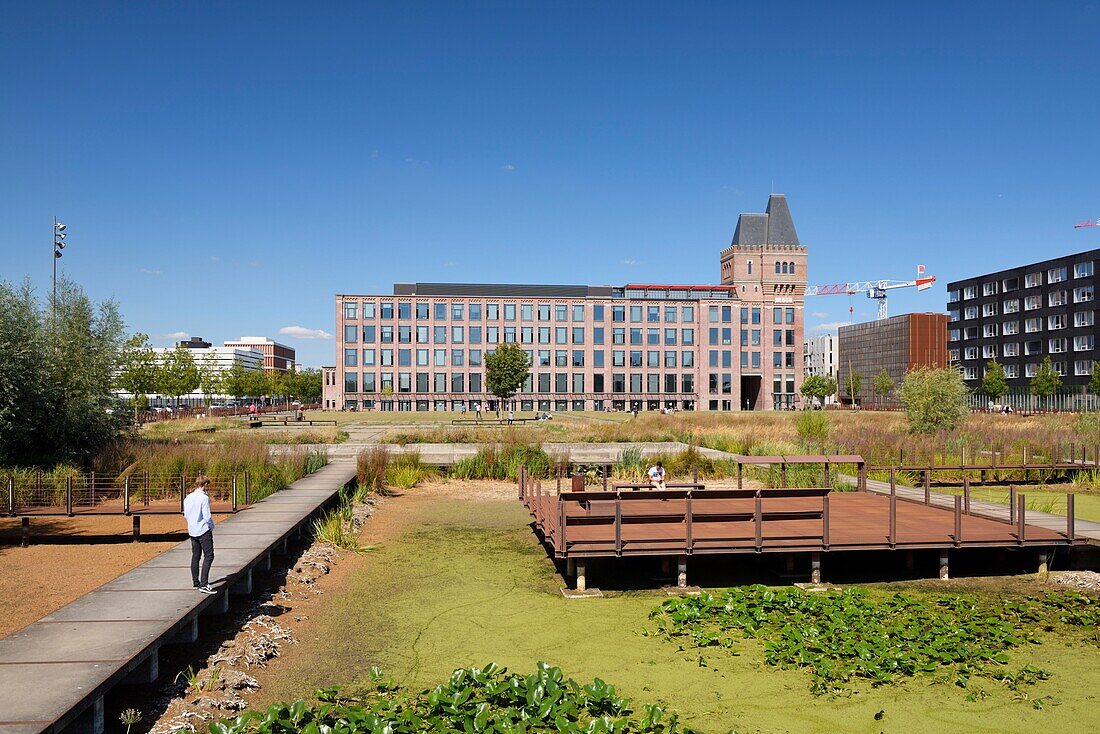 Frankreich, Nord, Lille, Bezirk Bois Blancs, EuraTechnologies business park pole of excellence, gewidmet dem TIC der Metropole Lille, das in der Blan Lafont, einer alten Spinnerei aus dem Jahr 1900, stattfindet, Mann mit Hemd auf einem Ponton, der es erlaubt, zwischen den Entspannungsbereichen zu gehen