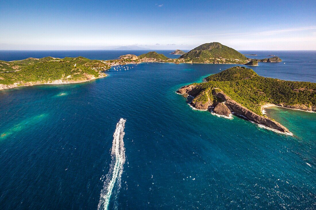 Guadeloupe, Les Saintes, Terre de Haut, the bay of the town of Terre de Haut, listed by UNESCO among the 10 most beautiful bays in the world, Dominica island in background (aerial view)\n