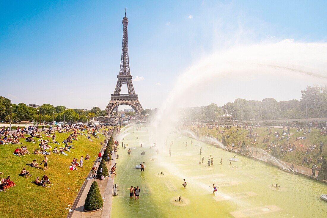 Frankreich, Paris, von der UNESCO zum Weltkulturerbe erklärtes Gebiet, die Trocadero-Gärten vor dem Eiffelturm, bei heißem Wetter, Baden und Wasserkanone