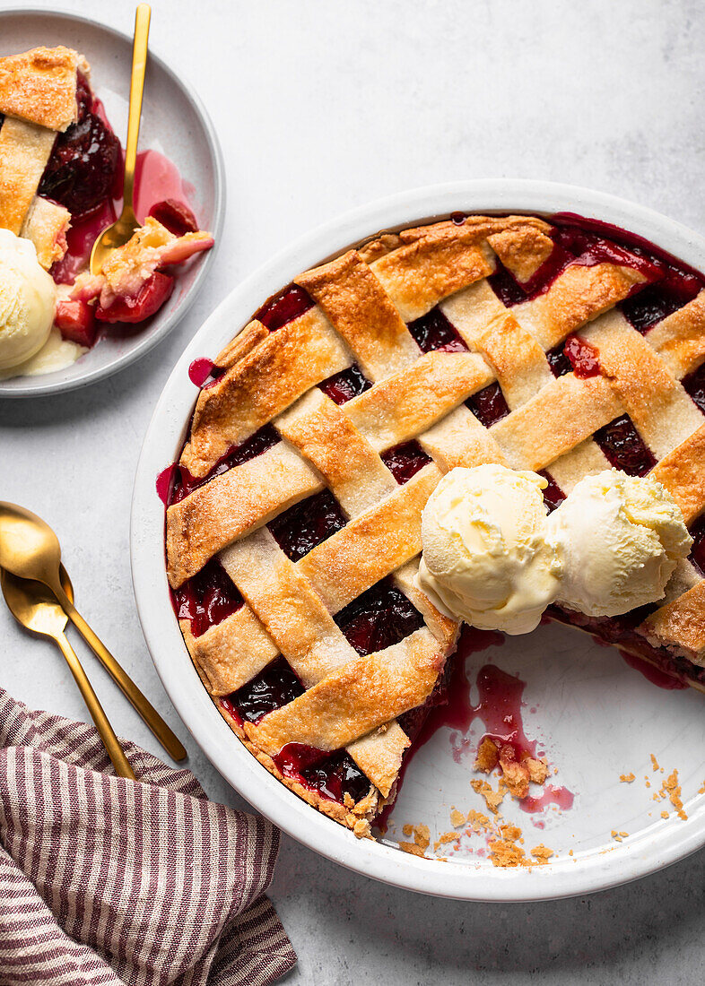 Plum pie with lattice crust served with vanilla ice cream