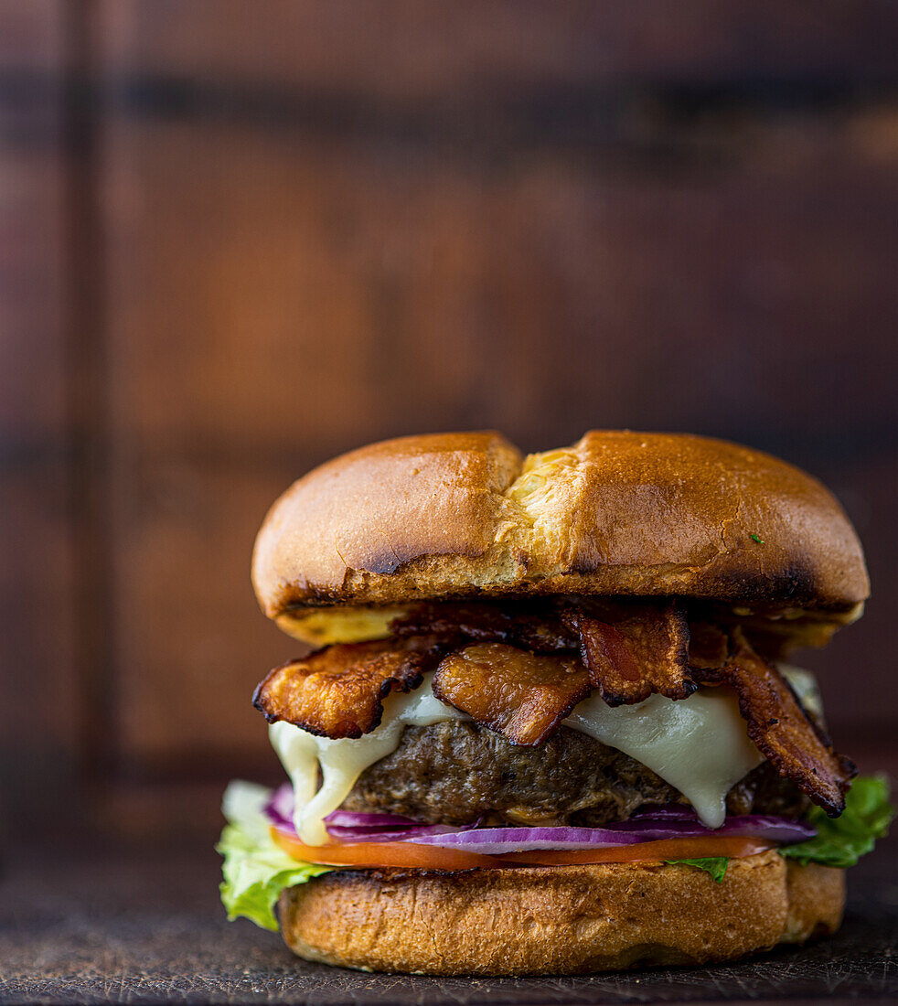 Beef burger with bacon, Swiss cheese, lettuce, tomato and red onion