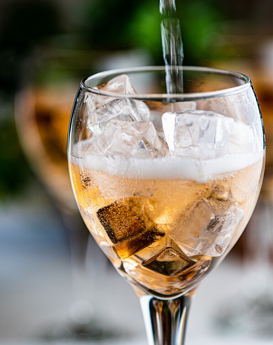 Rosé Spritzer in ein Glas schütten