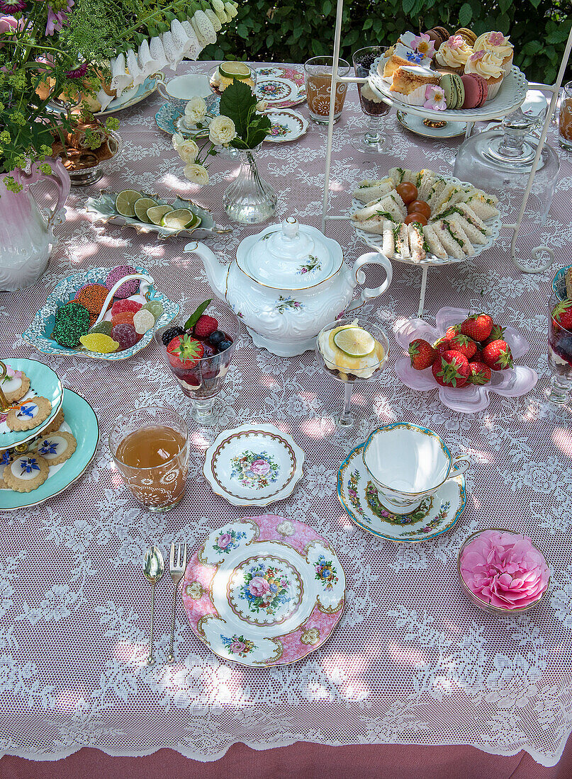 Kaffeetafel im Garten mit feinem Porzellan und selbstgebackenem Gebäck und Fingerfood