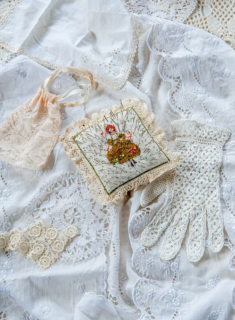 Vintage lace and embroidered pincushion on white crocheted textiles