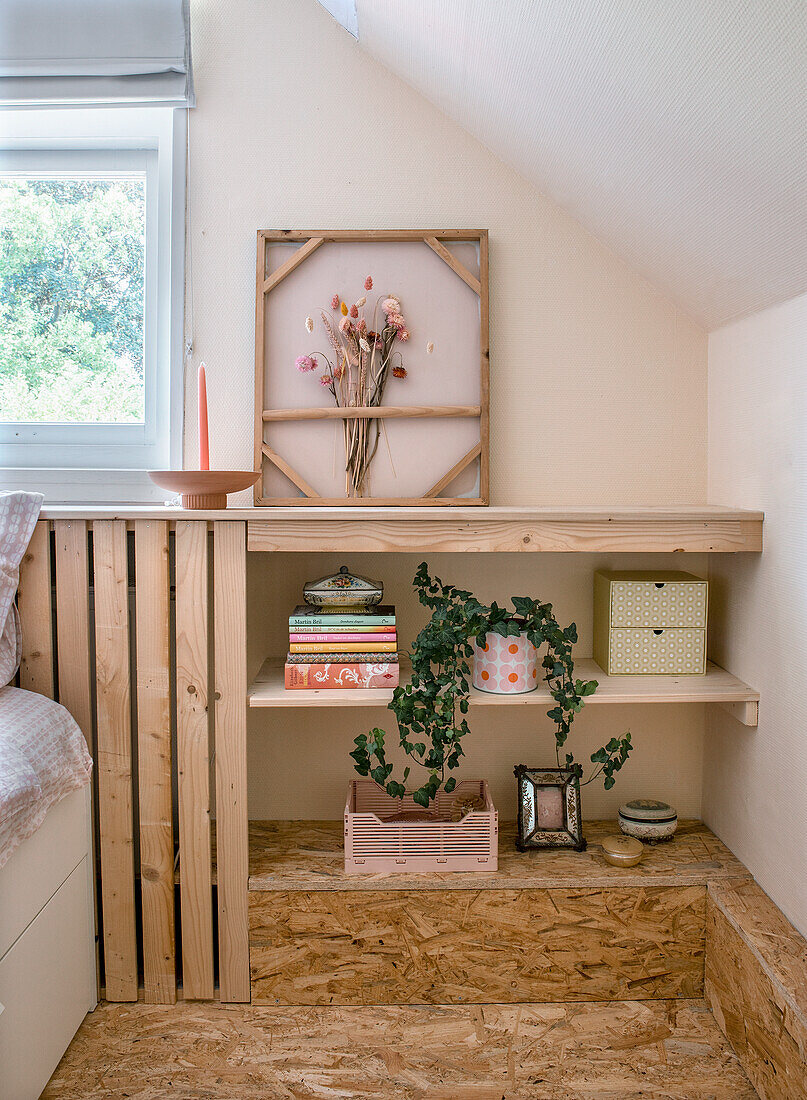 Wooden shelf, plant and decoration under sloping ceiling