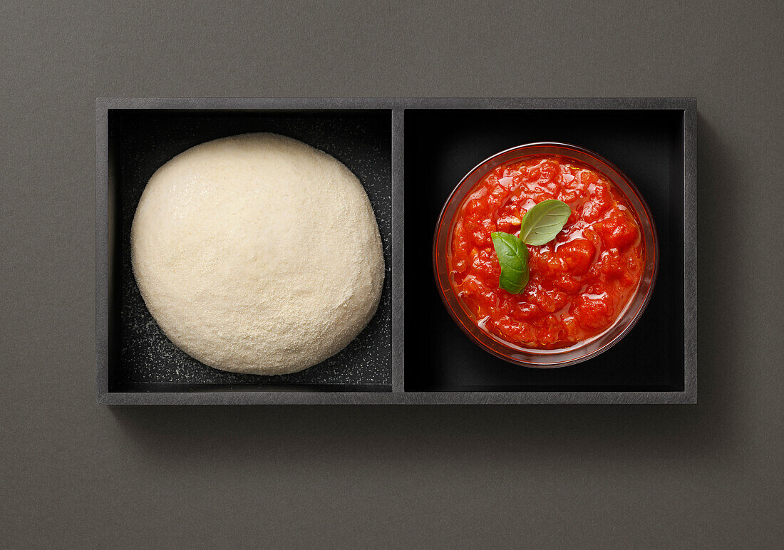 Tray with dough balls for pizza and tomato sauce