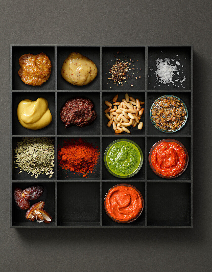 Tray with various sauces, spices, pine nuts and dates