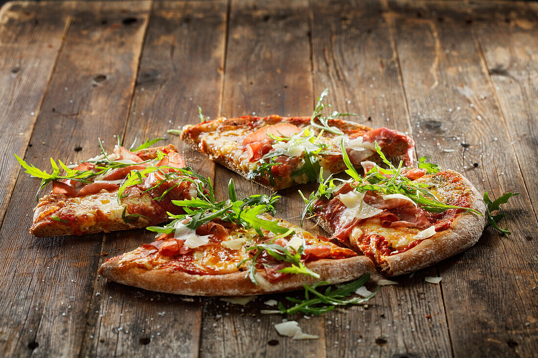 Wholemeal pizza with four types of cheese, sun-dried tomatoes, bresaola and rocket salad