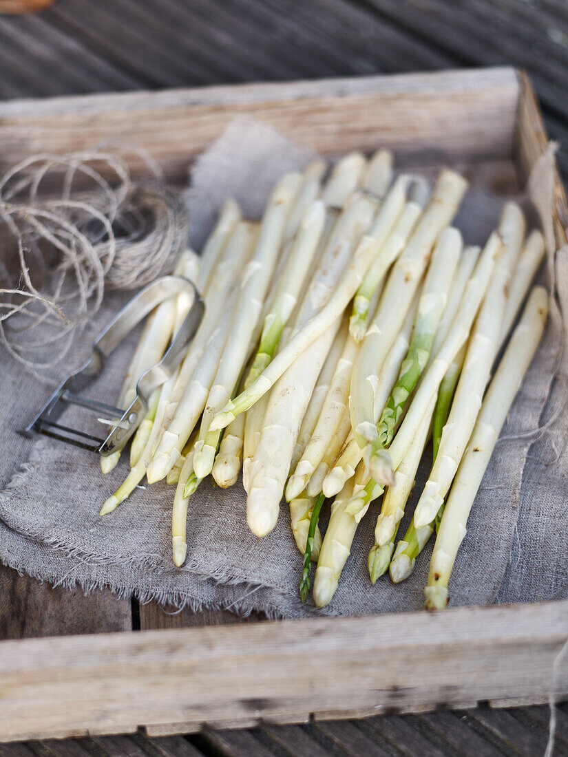 White asparagus spears in a wooden crate