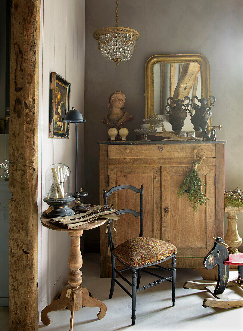 Antique side table, chair and wooden cabinet with decorative objects and mirror