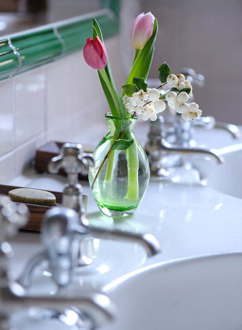 Tulip (Tulipa) and lily of the valley (Convallaria majalis) in a vase on a sink