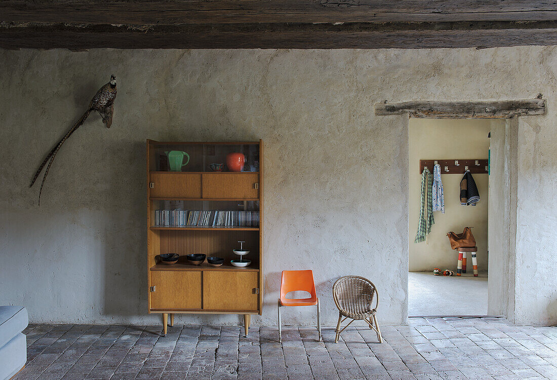 Mid-century bookcase in a rustic room with wooden beam ceiling