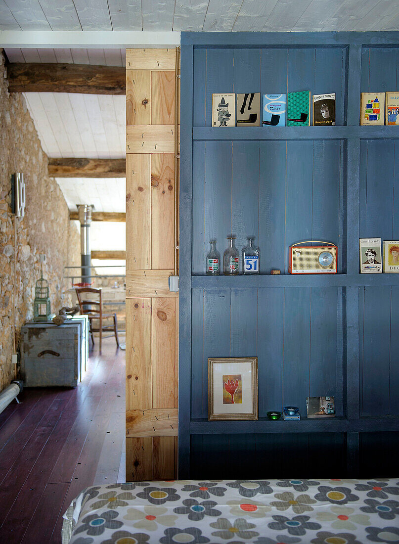 Blue, floor-to-ceiling shelving in the bedroom