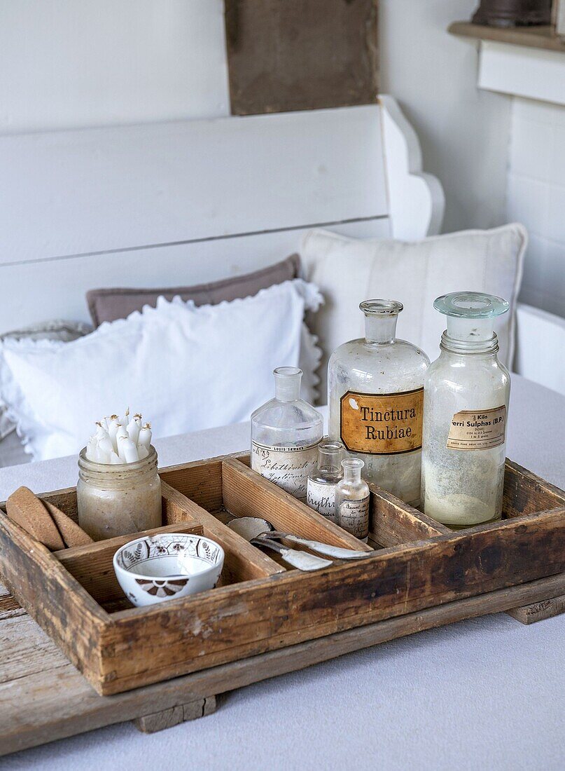 Old apothecary bottles and small bowls on a wooden tray