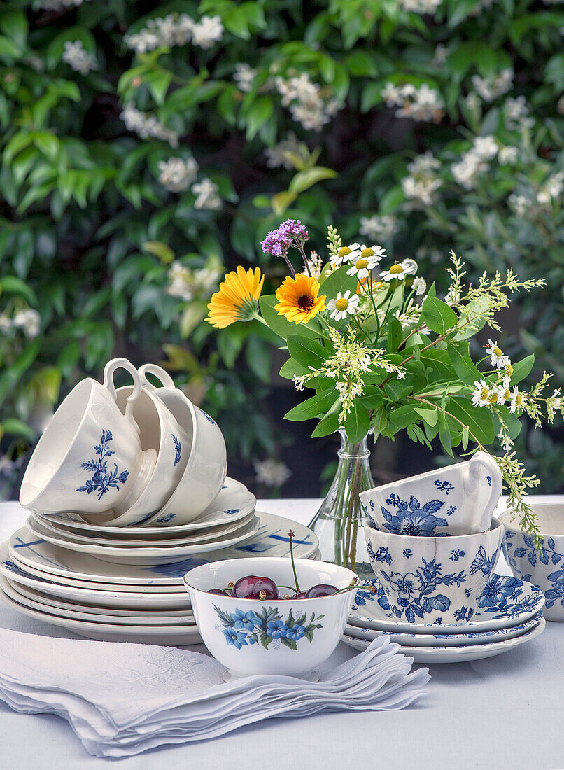 Sommerliche Tischdekoration mit Blumengedeck und Wildblumenstrauß