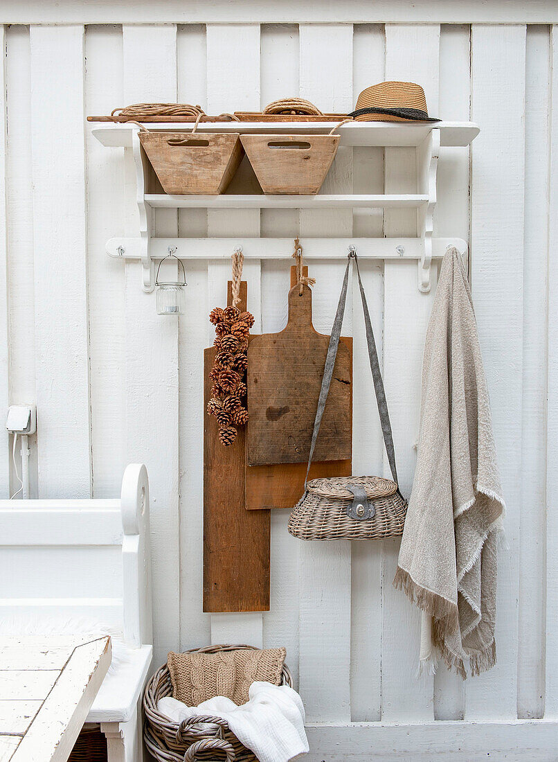 Kitchen wall with wooden boards, baskets and country-style towel hooks