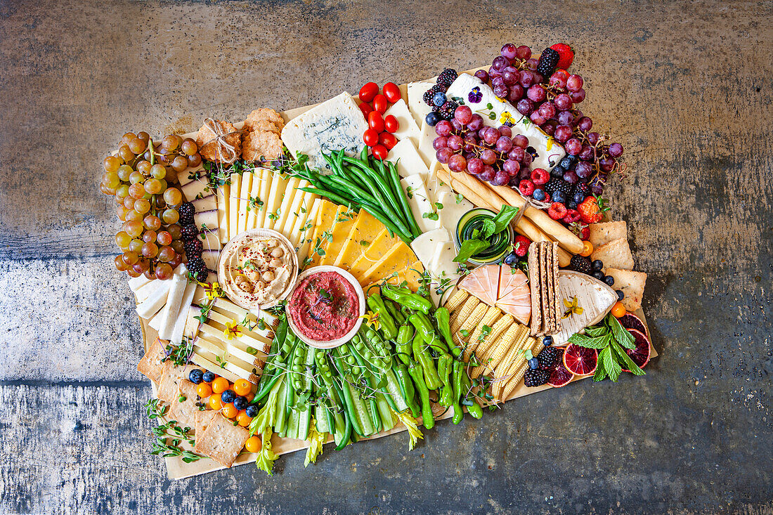 Cheese platter with vegetables and grapes