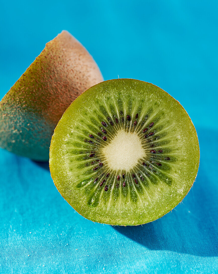 Halbierte Kiwi auf blauem Untergrund