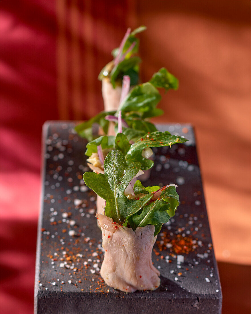 Beef sushi with rocket salad