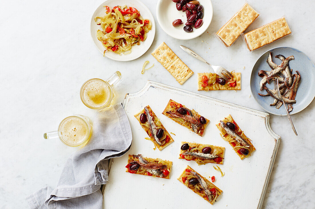 Crackers with anchovies, olives and vegetables