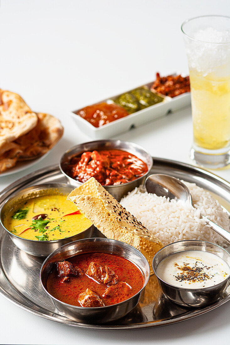 Three Indian curry dishes: coconut fish curry, beef vindaloo and tandoori chicken