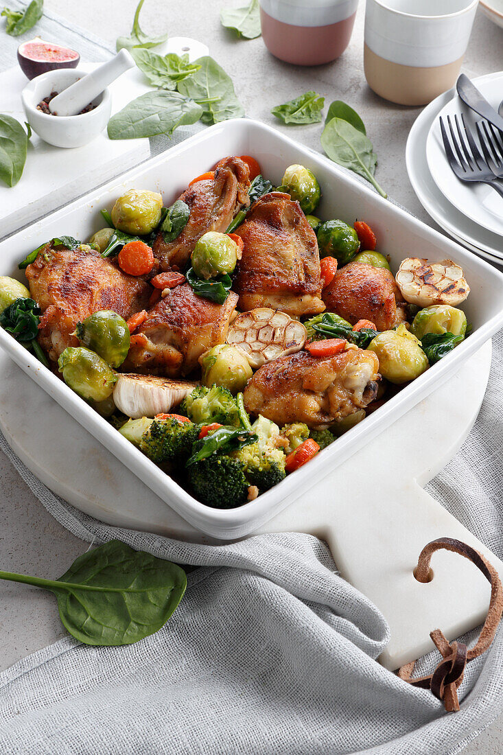 Roast chicken with carrots, broccoli, Brussels sprouts and garlic