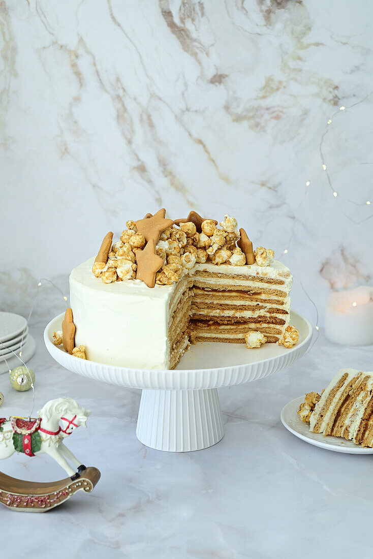 Honigkuchen mit Karamell und Sauerrahm, dekoriert mit Keksen und Popcorn