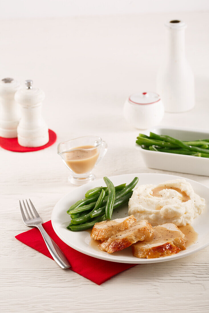 Turkey with gravy, mashed potatoes and green beans