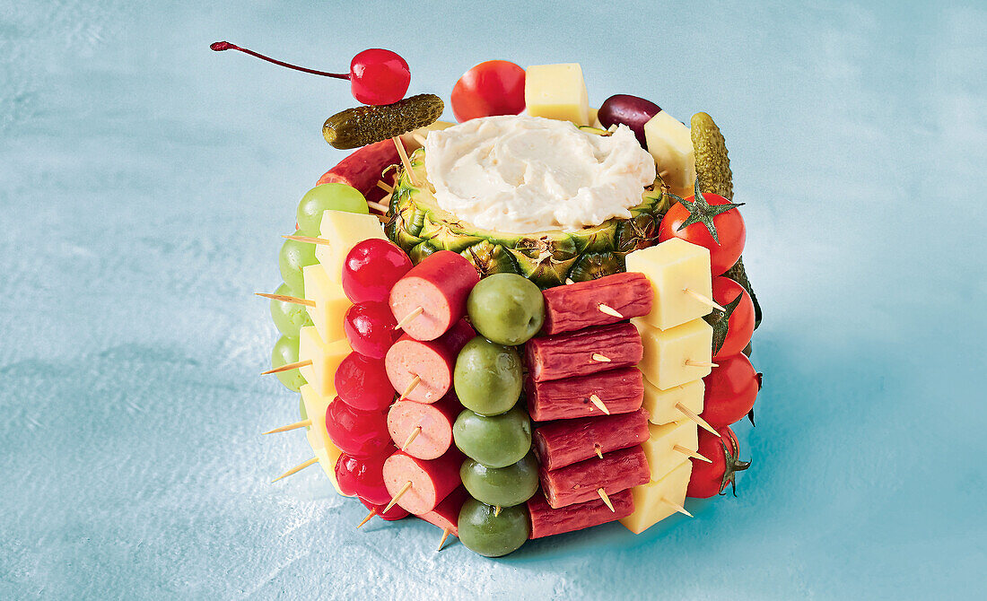 Pineapple finger food bomb with cheese, sausage, olives and tomatoes