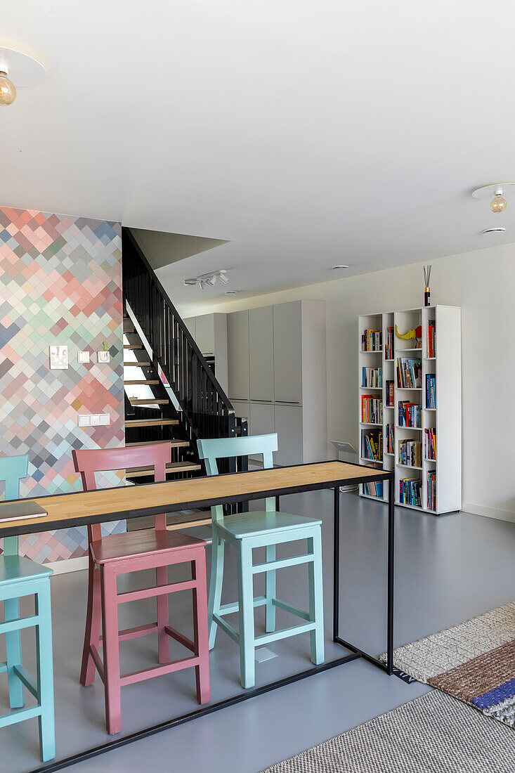 Open-plan living room with counter and colorful bar stools