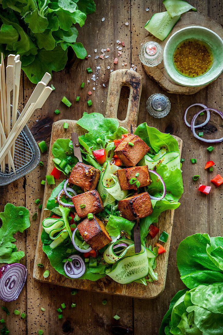 Salad with cucumber, onion and tofu skewers