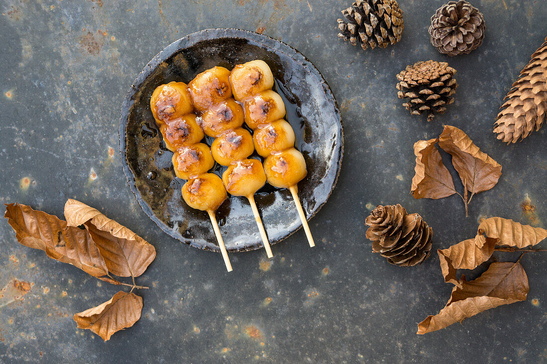 Gegrillte Mochi auf Spießchen mit Herbstdekoration