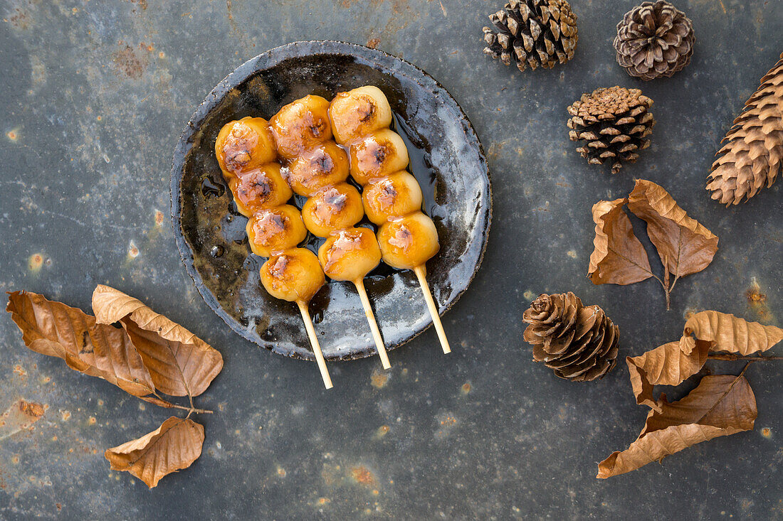 Grilled mochi on skewers with autumn decorations