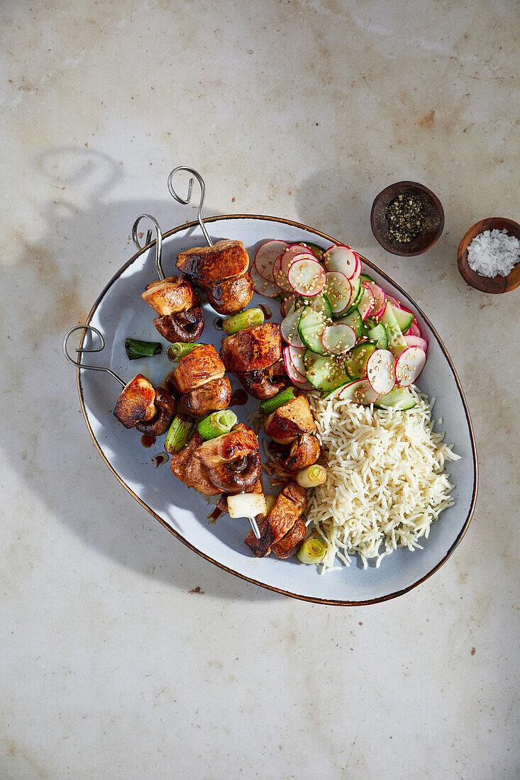 Chicken skewers with radish and cucumber salad and rice