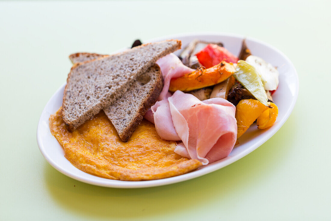 Cheese omelette with brown bread, vegetables and boiled ham