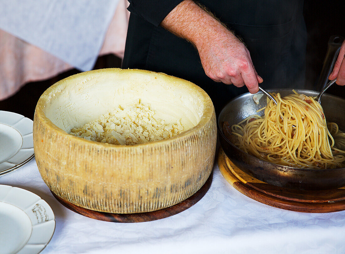 Spaghetti with pork cheek in a pecorino cheese wheel