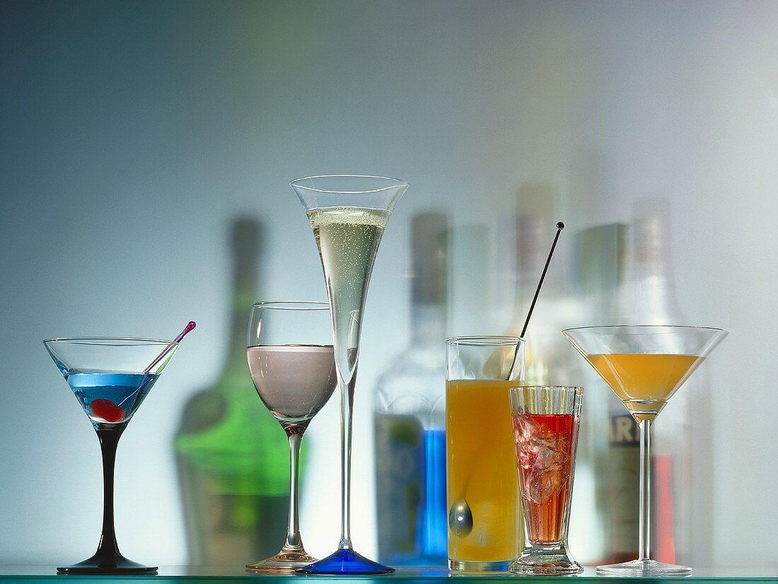 Colourful cocktails in glasses & coloured shadows of bottles