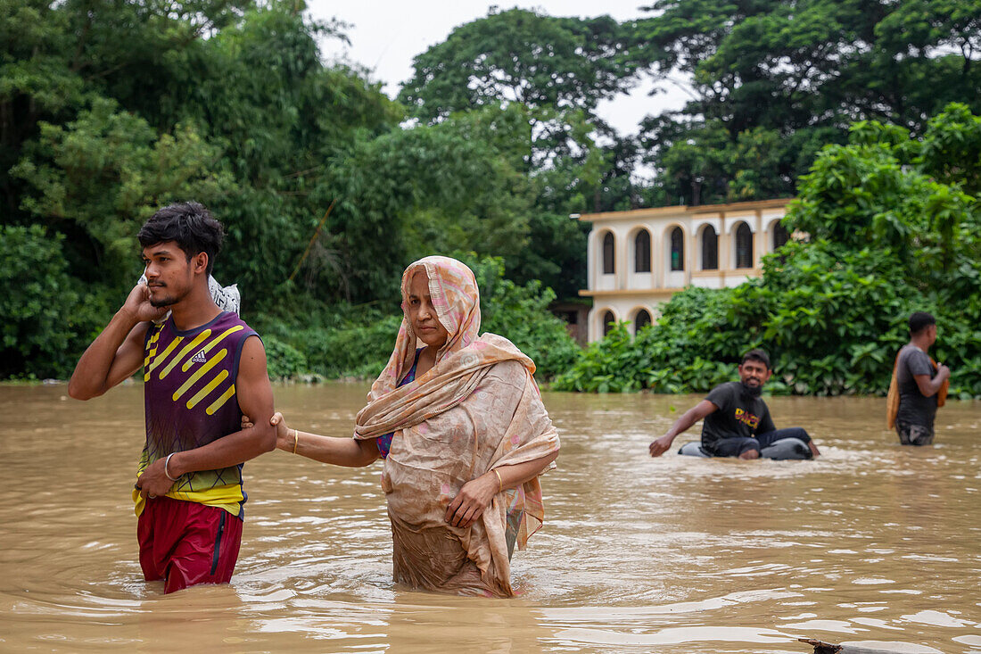 People walking through floodwater, Satkania Upazila, Bangladesh