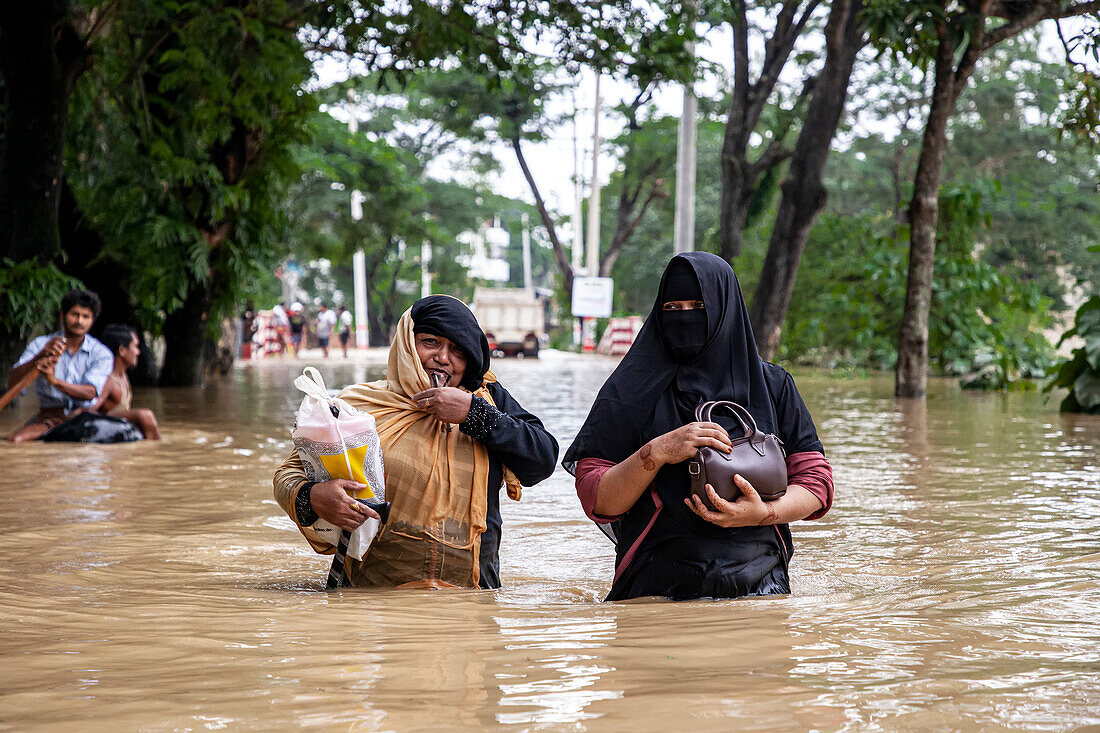Women walking through floodwater, Satkania Upazila, Bangladesh