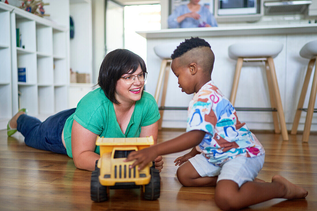 mother and son playing with toy dump truck