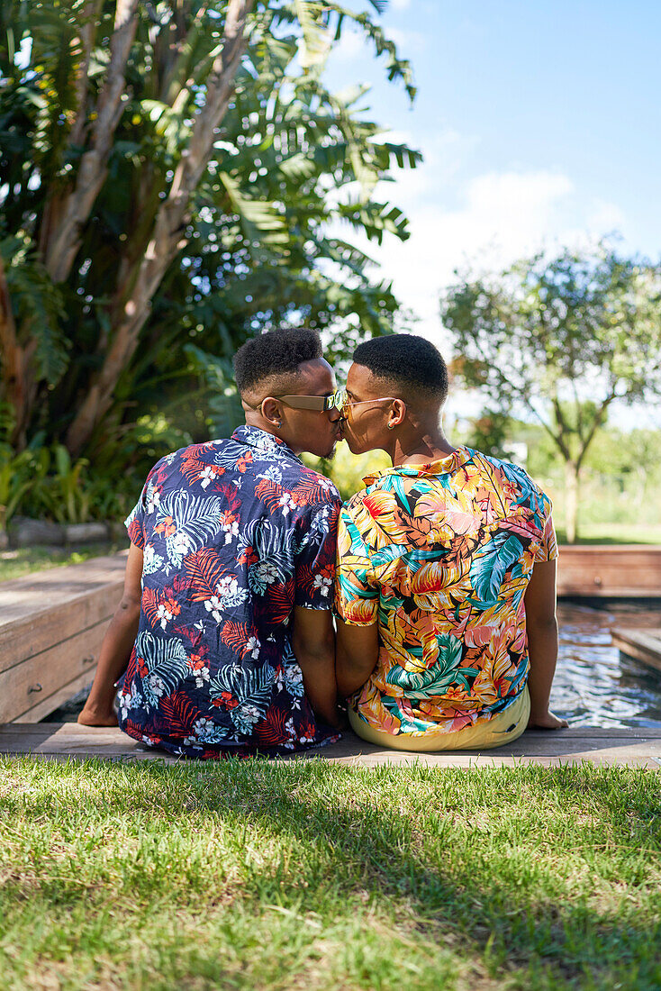 Young gay male couple kissing