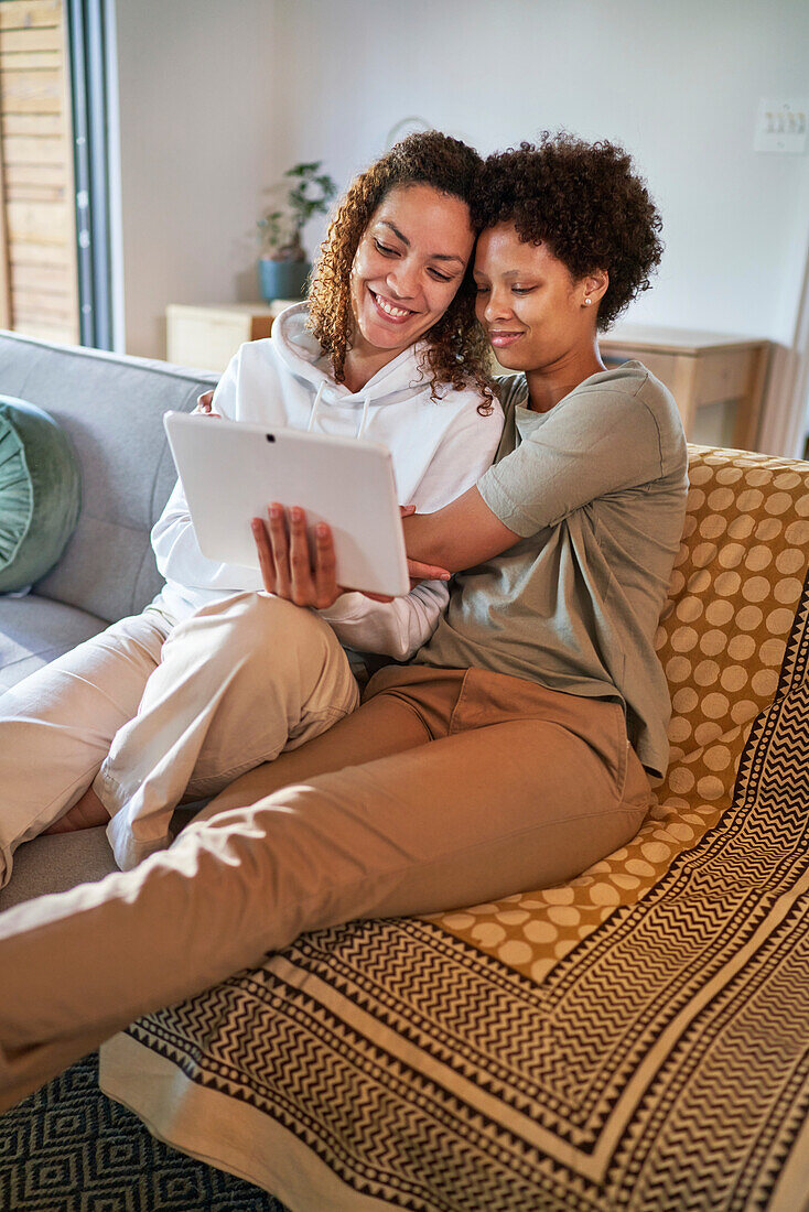 Happy lesbian couple using digital tablet