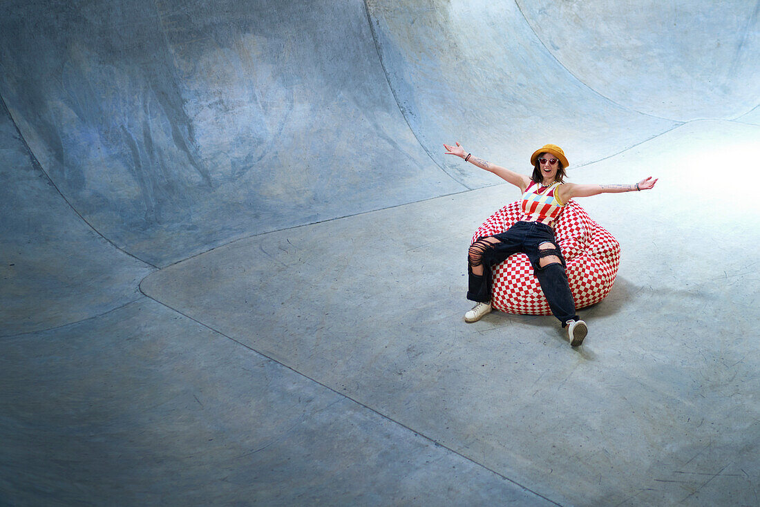 Young woman in beanbag chair on skate ramp